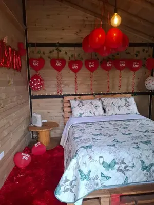 a bedroom with a bed with red paper hearts on the wall at Alma Cabañas y Spa in Guarne