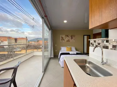 a kitchen with a sink and a bed in a room at Horus Loft - Con Terraza en todo el Centro in Carmen de Viboral