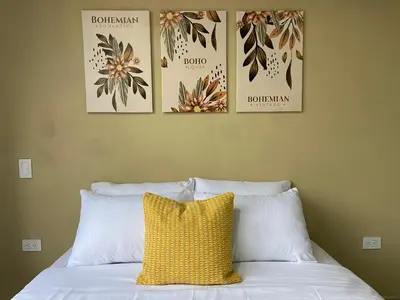a bed with a yellow pillow and three pictures on the wall at Horus Loft - Con Terraza en todo el Centro in Carmen de Viboral