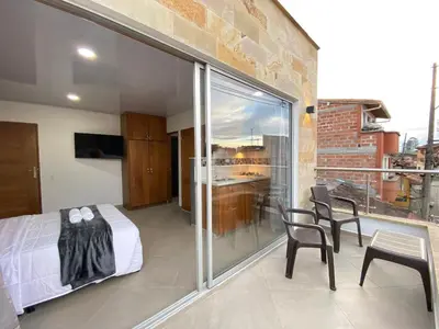 a bedroom with a bed and a balcony at Horus Loft - Con Terraza en todo el Centro in Carmen de Viboral