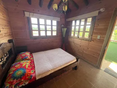 a bedroom with a bed in a wooden cabin at Loge Cabaña peñol-Guatape in El Peñol