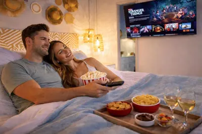 a man and a woman laying in bed with a tray of food at Chill-Out | Jacuzzi todo el año | Unicentro 5 minu in Medellín