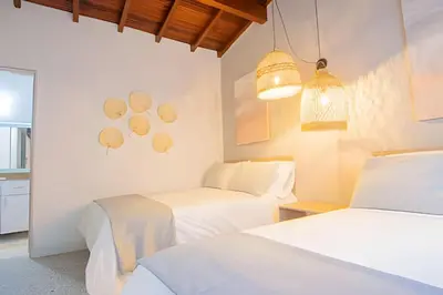 two beds in a room with white walls at Chill-Out | Jacuzzi todo el año | Unicentro 5 minu in Medellín
