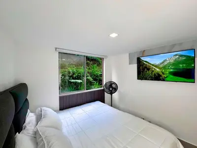 a bedroom with a bed and a tv on the wall at 3BR Family & Corporate Friendly El Poblado in Medellín