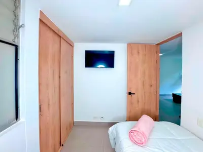 a bedroom with a bed with a pink pillow on it at 3BR Family & Corporate Friendly El Poblado in Medellín