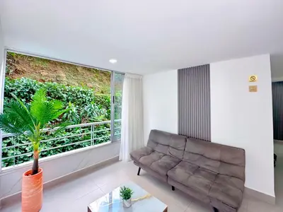 a living room with a couch and a large window at 3BR Family & Corporate Friendly El Poblado in Medellín
