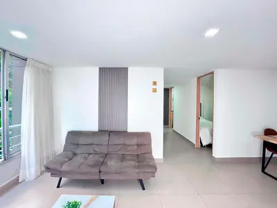 a living room with a couch and a bedroom at 3BR Family & Corporate Friendly El Poblado in Medellín