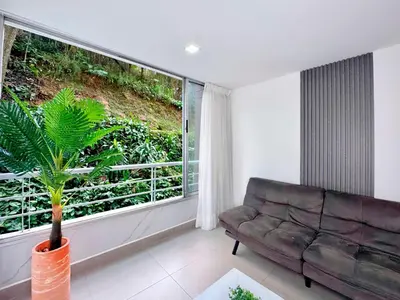 a living room with a couch and a large window at 3BR Family & Corporate Friendly El Poblado in Medellín