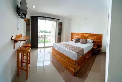 a bedroom with a bed and a large window at Hotel Las Vegas in Rionegro
