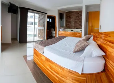 a bedroom with a large wooden bed in a room at Hotel Las Vegas in Rionegro