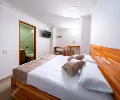 a bedroom with a large bed with a wooden headboard at Hotel Las Vegas in Rionegro