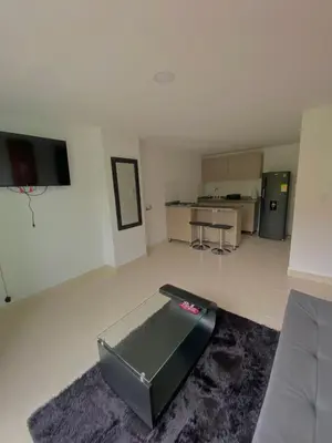 a living room with a couch and a kitchen at Apartamento Urban Manizales in Manizales