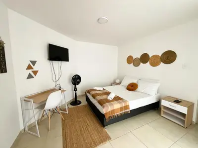 a bedroom with a bed and a desk and a tv at Loft dreams 7005 in Medellín