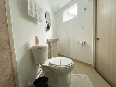 a white bathroom with a toilet and a mirror at Loft dreams 7005 in Medellín