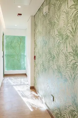 a hallway with a wall mural of palm trees at Sloh Hotel & Bar Manila Medellin in Medellín