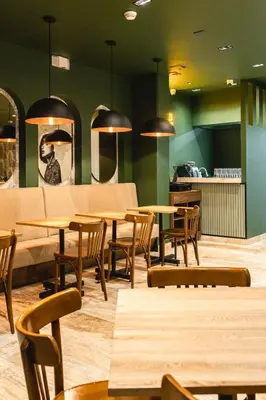 a restaurant with tables and chairs and a couch at Sloh Hotel & Bar Manila Medellin in Medellín