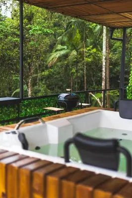 a hot tub on a deck with a view of the forest at Cabaña Montecielo San Rafael in San Rafael