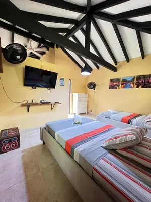 a bedroom with two beds and a flat screen tv at Finca en Sopetran in Sopetran