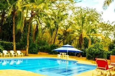 a swimming pool with chairs and an umbrella at Villa Privada con entrada y salida 100 por ciento flexible in La Florida
