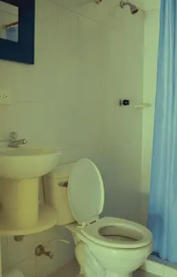 a bathroom with a toilet and a sink at Villa Privada con entrada y salida 100 por ciento flexible in La Florida