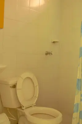 a bathroom with a toilet with the lid up at Villa Privada con entrada y salida 100 por ciento flexible in La Florida