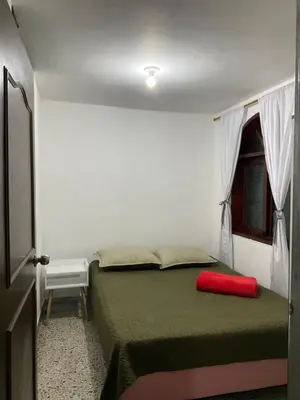 a bedroom with a bed with a red pillow on it at Medellin Apartamento con hermosa vista in Medellín
