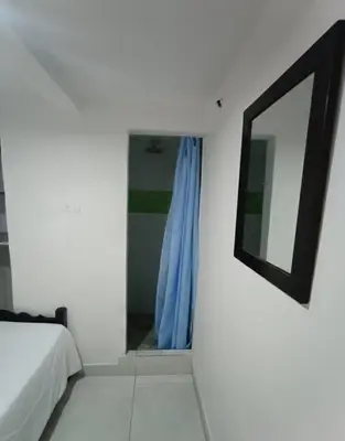 a bedroom with a mirror on the wall and a bed at Corazón Verde in Itagüí