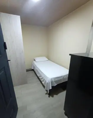 a small room with a bed and a television at Corazón Verde in Itagüí