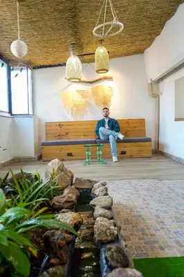 a man sitting on a bench next to a pond at Corazón Verde in Itagüí