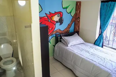 a bedroom with a bed with a painting on the wall at Corazón Verde in Itagüí