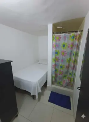 a bedroom with a bed and a shower curtain at Corazón Verde in Itagüí