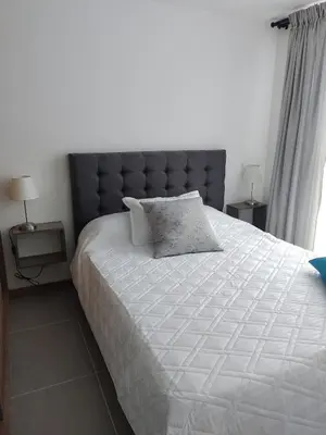 a bedroom with a large white bed with a blue headboard at Brand New Apartment Manizales in Manizales