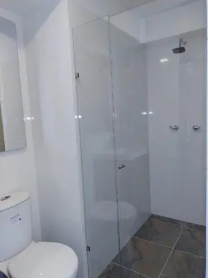 a bathroom with a toilet and a glass shower at Brand New Apartment Manizales in Manizales