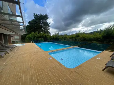 a large swimming pool on a patio next to a building at Suite de Lujo en Llano Grande - Piscina, jacuzzi, Turco, Gimnasio in Rionegro