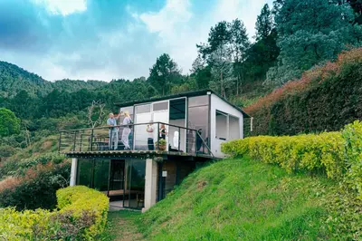 people standing on the balcony of a house on a hill at Cabaña sol in Medellín