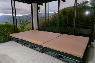 a bed sitting on a porch with a view at Cabaña sol in Medellín