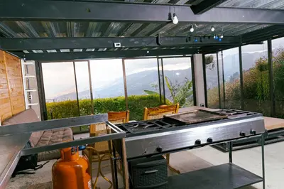 a kitchen with a grill and a view of the mountains at Cabaña sol in Medellín