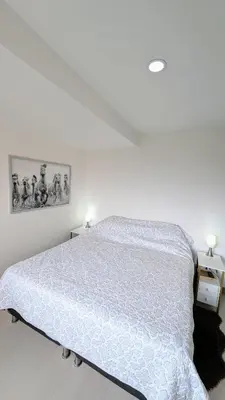 a bedroom with a bed with a white comforter at Beautiful Central Apartment in Sabaneta