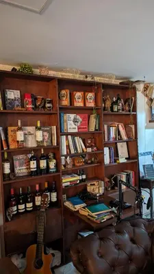 a book shelf filled with books and a guitar at Beautiful Central Apartment in Sabaneta