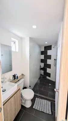 a bathroom with a white toilet and a sink at Beautiful Central Apartment in Sabaneta