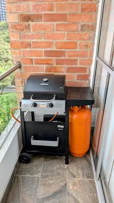 a grill sitting on a table next to a brick wall at Beautiful Central Apartment in Sabaneta