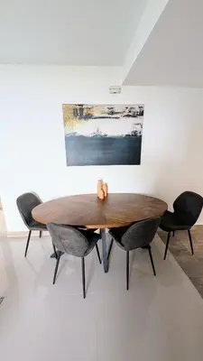a wooden table in a room with chairs and a painting at Beautiful Central Apartment in Sabaneta