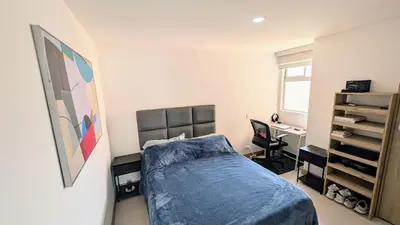 a bedroom with a bed and a desk at Beautiful Central Apartment in Sabaneta