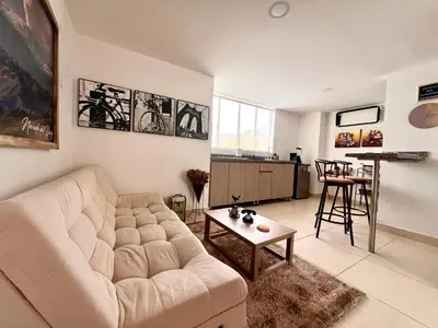 a living room with a white couch and a table at Cálido mini apartamento in Manizales