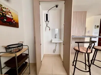 a small bathroom with a sink and two stools at Cálido mini apartamento in Manizales