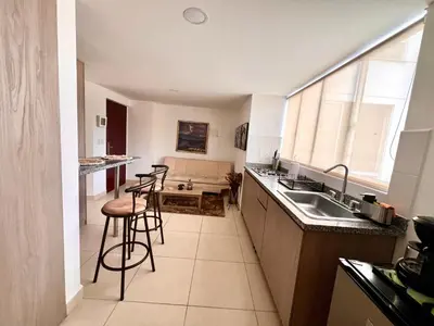 a kitchen with a sink and some bar stools at Cálido mini apartamento in Manizales