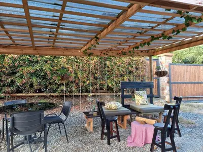 a patio with chairs and a wooden pergola at EpicBK Casa Campestre en San Pedro Antioquia in Zatra Tobón