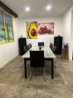 a table and chairs in a room with paintings at Alojamiento con vista al río y paisajes hermosos in Manizales