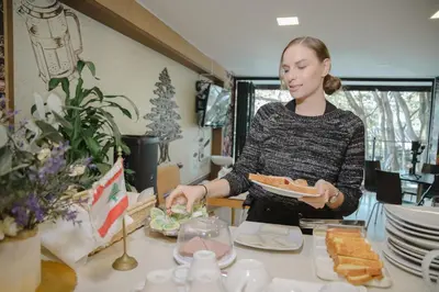 a woman holding a plate of food on a table at Edificio Fenicia Lofts Laureles in Medellín