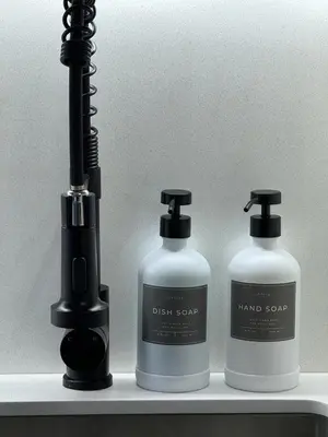 two bottles of hand soap and a blow dryer on a shelf at Luxury Apartment Jacuzzi Air Conditioning Fireplace and King Bed in Medellín